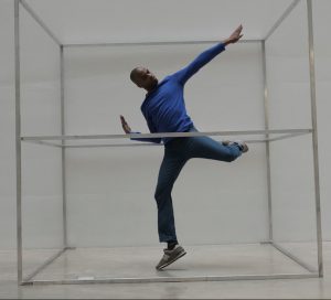 Christopher Rasheem-McMillan dancing in a transparent box